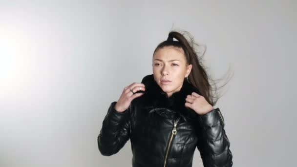 Kaukasische Brünette Modell im Studio auf Verschleiß Jacke Herbst warm close Konzept. Zeitlupe im Wind — Stockvideo