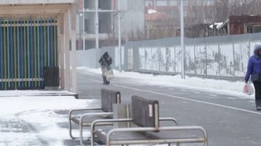 Kaliningrad/Rusya-02062018: Bir adam bir el arabası ile kış boş şehrin içinden girer.