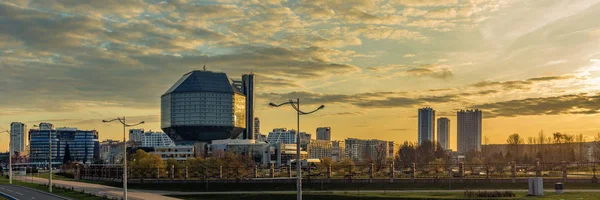 Minsk 'teki ulusal kütüphanenin modern çeyreğinin panoramik görüntüsü şafaktan itibaren yanal güneş ışığıyla