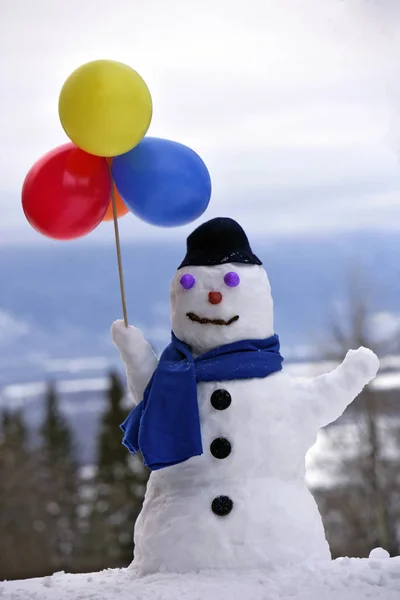 Smiling snowman with balloons.