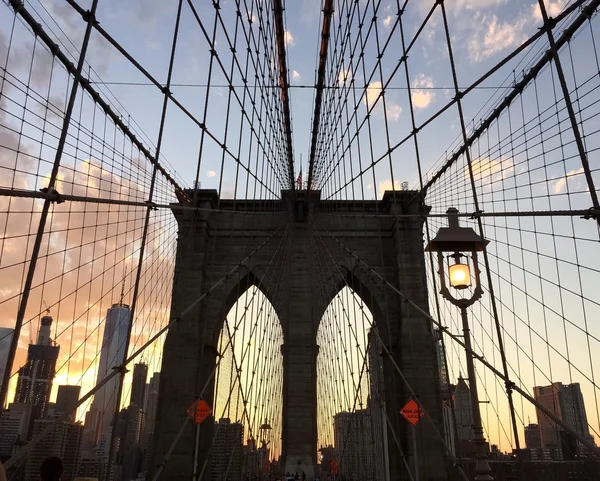 Silhueta da ponte de Brooklyn e os edifícios com céu por do sol — Fotografia de Stock