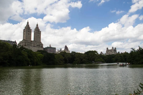 Edificios y lago en Central Park con puesta de sol azul nublado, Nueva York — Foto de Stock