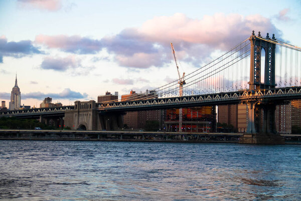 Manhattan bridge and the city with cloudy sunset sky, New York