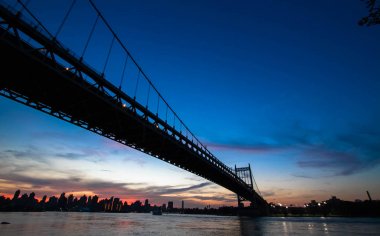 Triborough Köprüsü nehir ve Binalar siluet ve günbatımı gökyüzü üzerinde