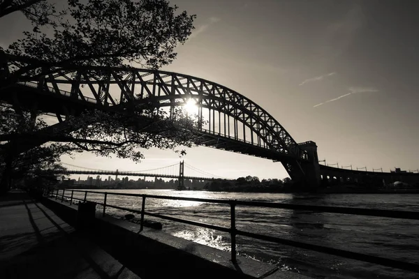 A ponte Hell Gate Bridge e a ponte Triborough sobre o rio com passarela no parque Astoria em estilo preto e branco, Nova York — Fotografia de Stock