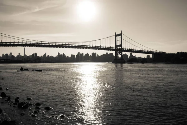 Silhueta da ponte Triborough sobre o rio e a cidade em estilo vintage escuro, Nova York — Fotografia de Stock