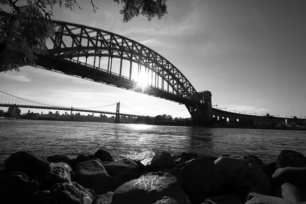 A ponte do portão do inferno e rochas, e o sol reflete no rio em estilo preto e branco, Nova York — Fotografia de Stock