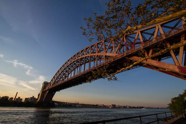 Hell Gate Bridge nad rzeką z zachód słońca niebo, Nowy Jork — Zdjęcie stockowe