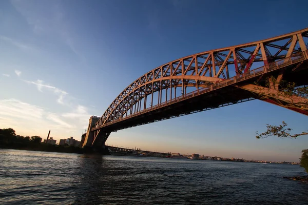 A Hell Gate híd a folyón, napnyugtakor ég, New York — Stock Fotó