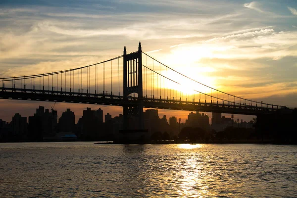 Ponte e città di Triborough con tramonto nella silhouette, New York — Foto Stock