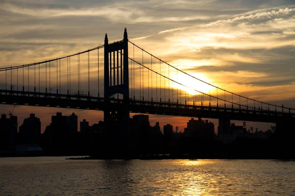 Ponte de Triborough e cidade com pôr do sol em silhueta, Nova York — Fotografia de Stock