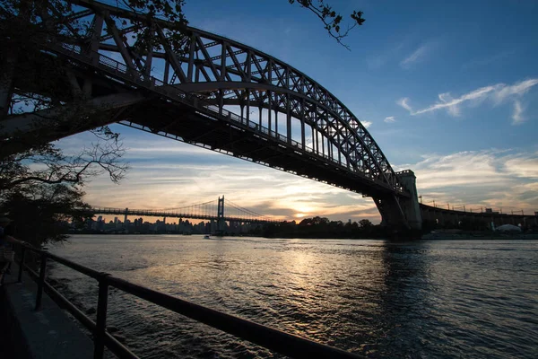 Hell Gate Bridge and in silhouette with sunset sky, New York — Stock Photo, Image