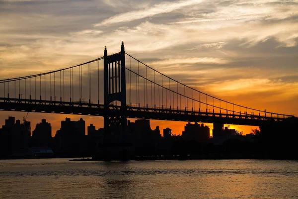 Ponte e cidade de Triborough com céu nublado ao pôr do sol, Nova York — Fotografia de Stock