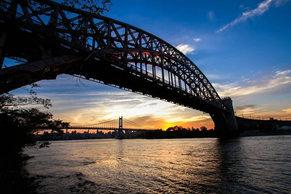 A sziluett, naplemente, New York-i előtt Hell Gate híd és a Triborough hidat — Stock Fotó