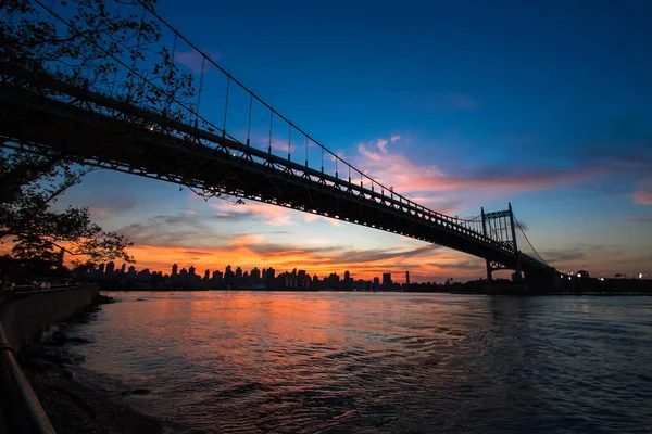 Triborough most přes řeku v siluetě před západem slunce — Stock fotografie