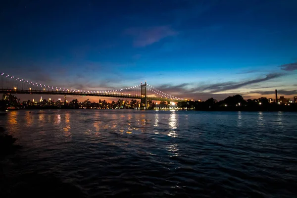 Ponte di Triborough sul fiume riflettente e gli edifici di notte, New York — Foto Stock