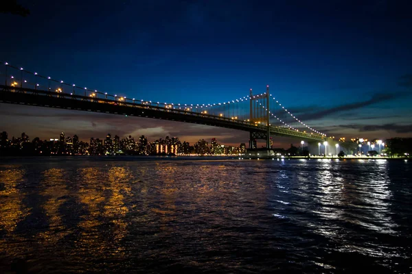 Triborough bridge nad rzeką i budynków w Manhattan nocą, Nowy Jork — Zdjęcie stockowe