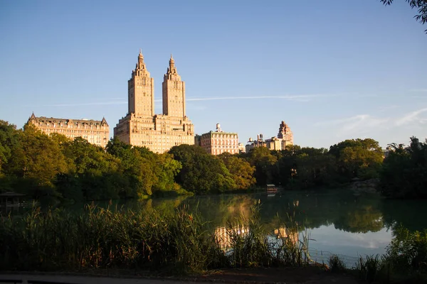 Edificios en Manhattan con lago y cielo azul en Central Park — Foto de Stock