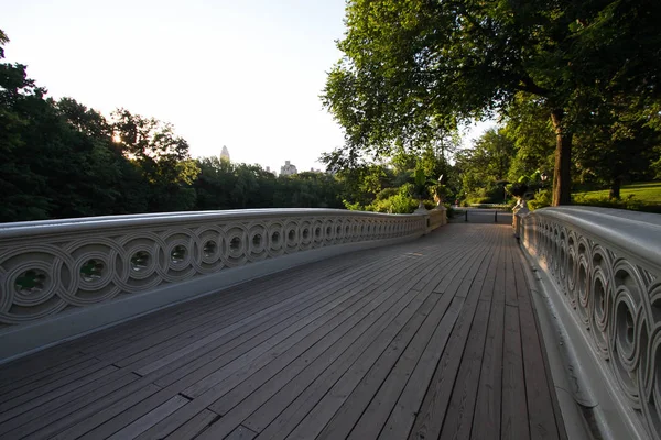 Houten loopbrug van Bow brug onder de schaduw en de bomen in Central Park — Stockfoto