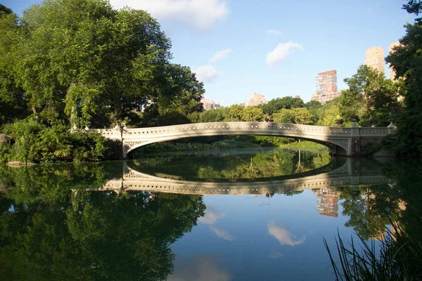 Bow bridge and trees clearly reflects on the lake at Central Park with sky — Stock Photo, Image