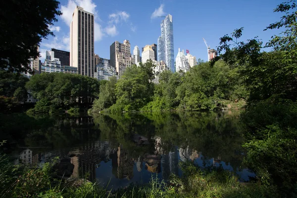 Reflecterende meer onder de schaduw en de gebouwen van Manhattan in de zomer — Stockfoto