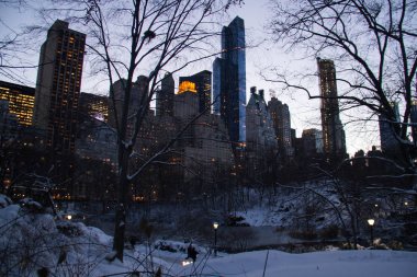 Işık ve geceden önce Central Park'ta kar ile binalar
