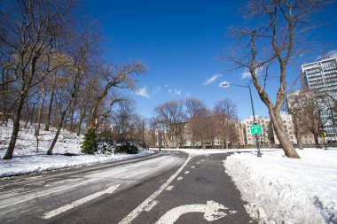 Ok ve mavi gökyüzü, New York Central Park'ta kar olan yol