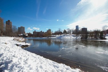 Göl, kar ve mavi gökyüzü ile binalar