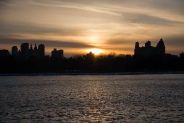 New York 'ta göl ve binalar üzerinde günbatımı