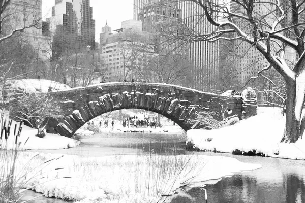 Gapstow brug en de sneeuw in Central Park en gebouwen van Manhattan in zwart-wit stijl — Stockfoto