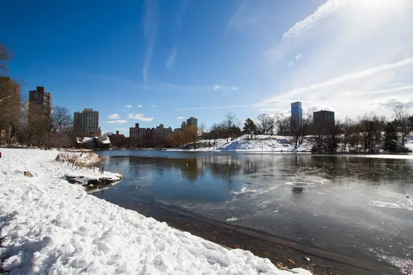 Bevroren meer, sneeuw en gebouwen met blauwe lucht — Stockfoto