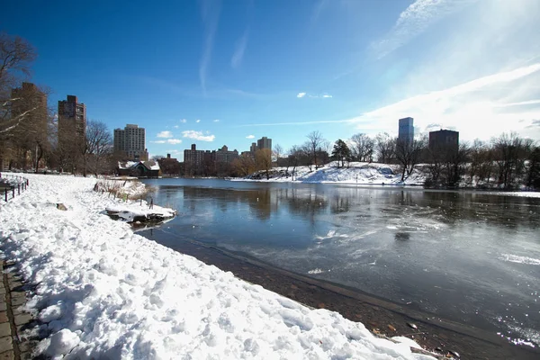 Byggnader reflektera över sjön och snö med blå himmel — Stockfoto