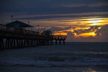 Sahilde bulutlu gökyüzü ile gündoğumu