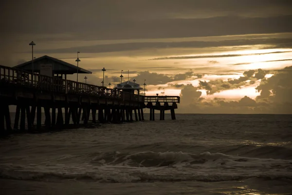 Donkere Oceaan en een pier met zonsopgang in vintage — Stockfoto