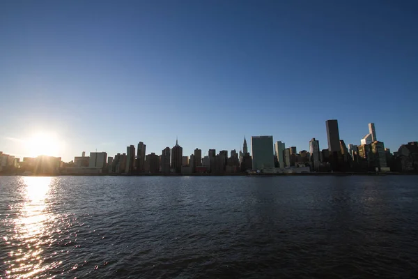 Gün batımı ile Manhattan şehir altında gölge ve Doğu Nehri