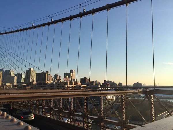 Edificios en Brooklyn detrás del cable del puente de Brooklyn con cielo al atardecer — Foto de Stock