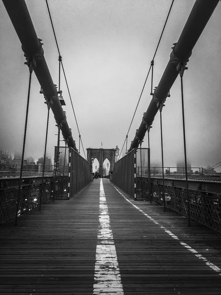 Пешеходная дорожка на Бруклинском мосту с туманом в черно-белом стиле — стоковое фото