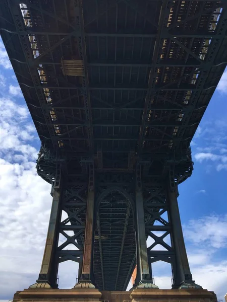 Строение под Манхэттенским мостом с облачным голубым небом — стоковое фото