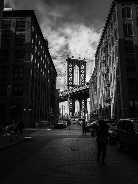 Manhattan Köprüsü binalar ve sokak ile bulutlu gökyüzü siyah ve beyaz arasında