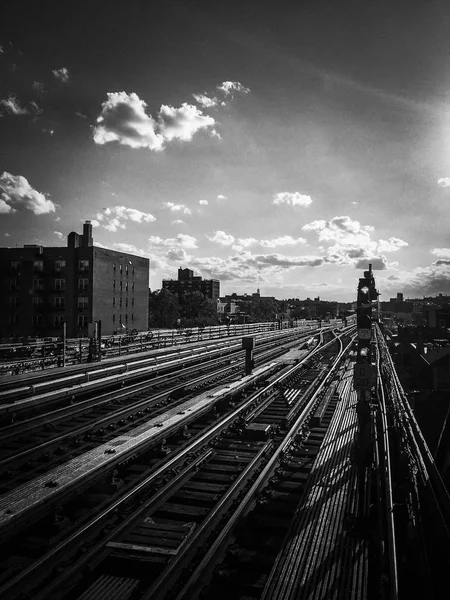 Tory kolejowe metra z pochmurnego nieba w czerni i bieli — Zdjęcie stockowe