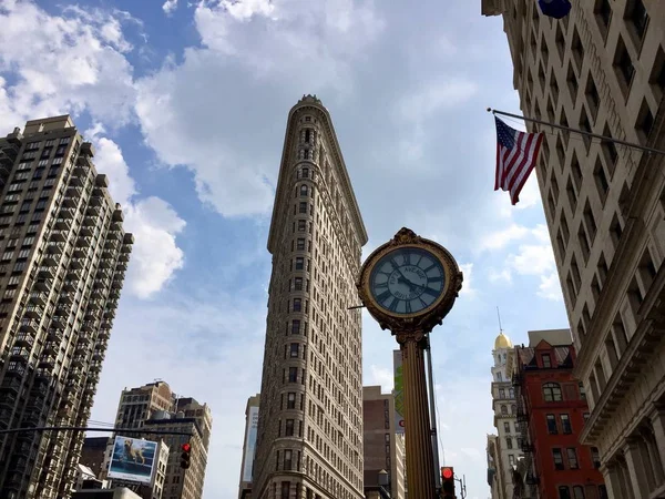 Manhattan, New York, 20 Temmuz 2017: Flatiron Binası ve bulutlu gökyüzü ile Fifth Avenue at saat