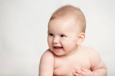 Beyaz arka plan üzerinde oturan gülümseyen kız bebek 