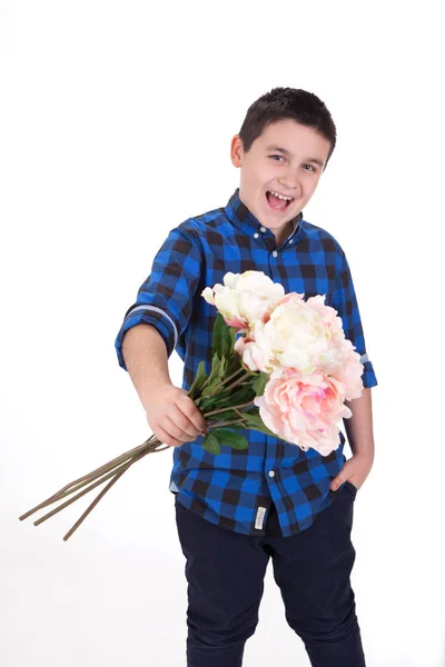 Portrait of a funny, happy young boy holding flowers to you, wit — Stock Photo, Image