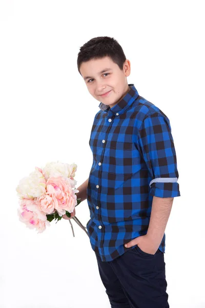 Porträtt av en leende ung pojke håller blommor, med vit rygg — Stockfoto