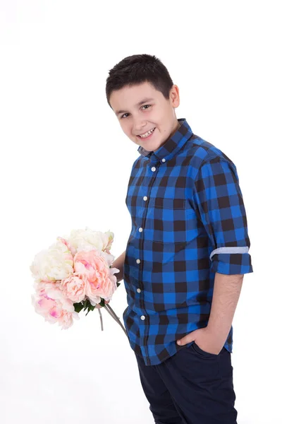 Portrait of a handsome happy young boy holding flowers, with whi — Stock Photo, Image