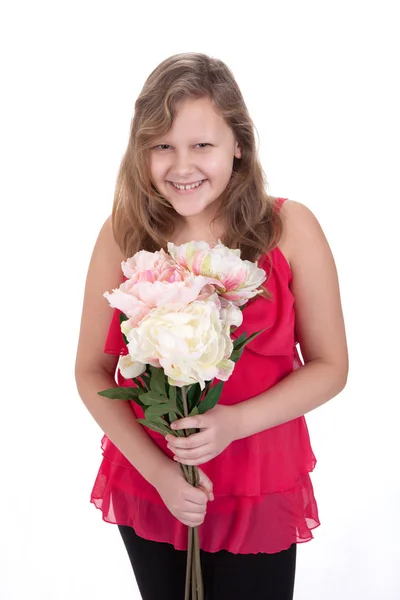 Portréja egy nevető fiatal lány gazdaság virágokkal, fehér ba — Stock Fotó