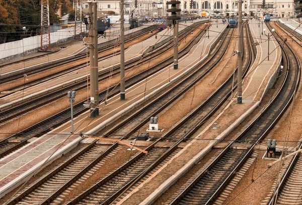 Binari ferroviari paralleli con stazione ferroviaria sullo sfondo — Foto Stock