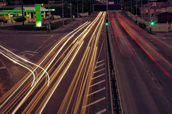 Strade cittadine e auto in movimento con luce sfocata attraverso — Foto Stock