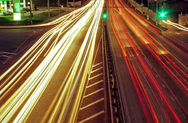 Strade cittadine e auto in movimento con luce sfocata attraverso — Foto Stock