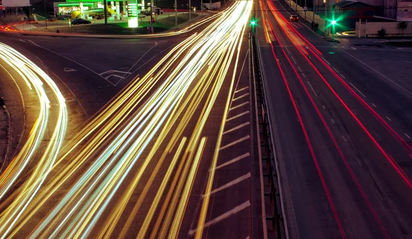 Strade cittadine e auto in movimento con luce sfocata attraverso — Foto Stock